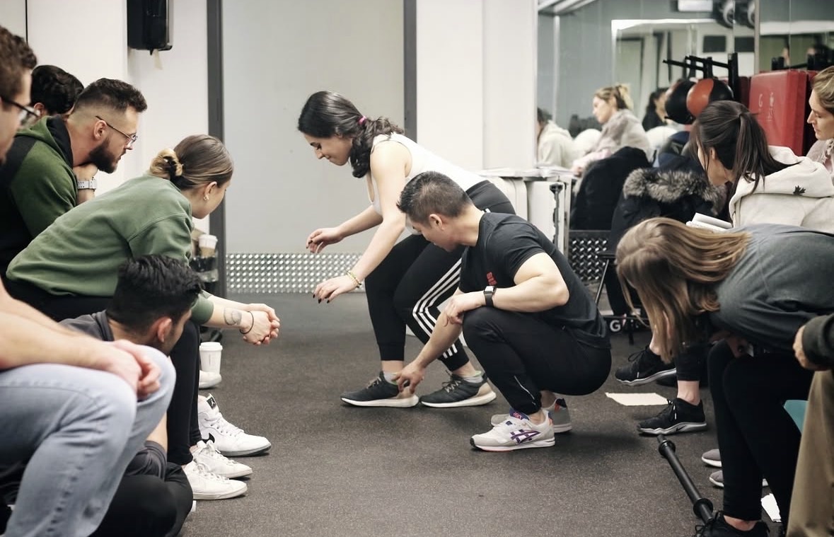 Steve Lee pointing to a participant’s ankle while teaching personal trainers